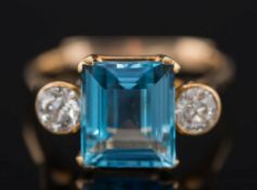 A gold, aquamarine and diamond three-stone ring: with central rectangular aquamarine,