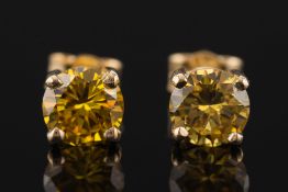 A pair of 18ct gold and yellow diamond single stone ear studs: each with a circular,