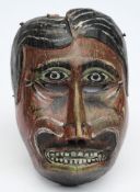An Oceanic carved wood and polychrome mask: having painted eyes and teeth, 25cm. high.