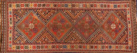 A Shiraz rug:, the field with four brick red hooked lozenge medallions and geometric designs,