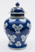 A Chinese blue and white baluster vase and cover: painted with prunus blossom on a cracked ice
