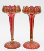 A pair of ruby glass table lustres: each with petal rim on an octagonal stem and circular foot cut