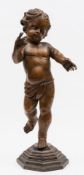 A 19th century Continental carved wooden figure of a Putto: wearing a loin cloth and mounted on a