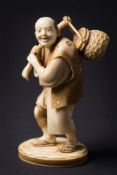 A 19th century Japanese carved ivory okimono: of a peasant in traditional costume,