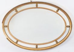 A giltwood and gesso oval marginal wall mirror:, the plate within a reeded and ribbon cross frame,