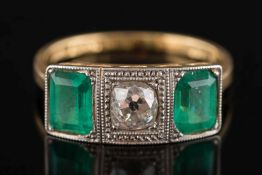 An 18ct gold, Art Deco style emerald and diamond three stone ring:, the central, cushion shaped,