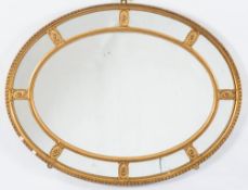 A giltwood and gesso oval marginal wall mirror:,