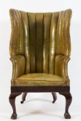 A 19th Century mahogany high back wing armchair:, of tub shaped outline in the Georgian taste,