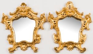 A pair of 19th Century Italian carved giltwood mirrors:, of cartouche shaped outline,
