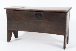 An 18th Century oak rectangular coffer:, of plank construction, the hinged top with gouged ends,