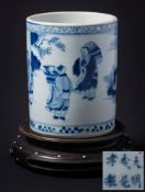 A Chinese blue and white cylindrical brushpot: painted with three figures and a deer in a