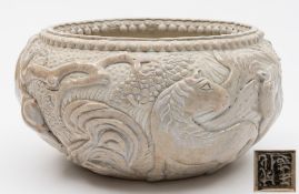 An unusual Chinese cream glazed stoneware bowl: decorated in relief with two horses amongst