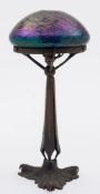 An Art Nouveau period bronze table lamp in the Loetz style with iridescent glass shade: the domed