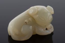 A Chinese carved jade figure of a reclining beast: the stone of  celadon colour, 5cm. long.