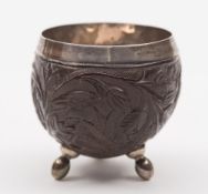 A small 19th century carved  coconut  and silver lined cup: decorated with swirling foliage and