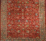 An Indo Persian carpet:, the rust field with an all over design of palmettes,