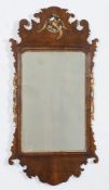 A 19th Century walnut and partly gilt fret cut wall mirror:, surmounted by a figure of a ho-ho bird,