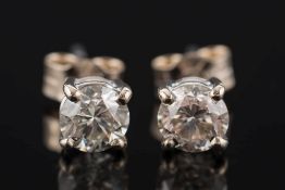 A pair of diamond single stone ear studs: with circular,