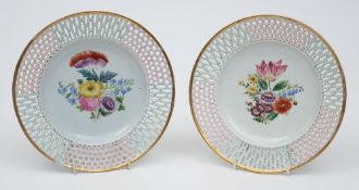 A pair of Wallendorf porcelain plates: of circular form with pierced rims picked out in pink and