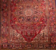 A Persian carpet of Heriz design:, the rose field with a central flowerhead medallion,