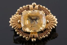 A mid 20th century gold and yellow sapphire single-stone brooch:,