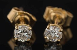 A pair of diamond single stone ear studs: each with a circular,