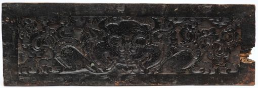 An 17th century (or later) Tibetan carved wood panel: depicting a horned devil, 25 x 76cm.