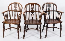 A harlequin set of four early 19th Century elm, ash and fruitwood stick back Windsor elbow chairs:,