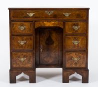 A burr walnut veneer, cross and feather banded kneehole desk in the early 18th Century taste:,