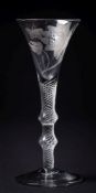 An air twist wine glass: the trumpet shaped bowl engraved with a single bloom and butterfly set on