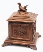 A Black Forest-style square tea caddy:, the hinged lid surmounted by a cockerel finial,