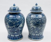 A pair of Chinese porcelain baluster jars and domed covers: painted in blue with panels containing