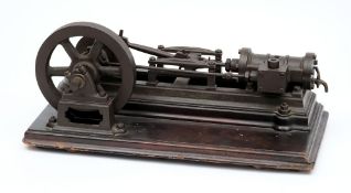A 19th century  single piston horizontal steam engine:, the 7 inch iron flywheel with brass crank,