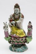 An unusual Chinese famille rose figure of Guanyin: wearing flowing robes and an elaborate necklace,
