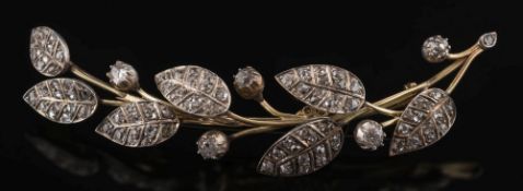 A yellow metal and diamond mounted leaf design spray brooch: pave-set with circular,