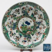A Chinese famille verte dish: painted with a central circular panel encircled with eight foliate
