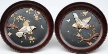 A pair of Japanese lacquered, ivory and mother-of-pearl decorated wall plaques: of circular form,