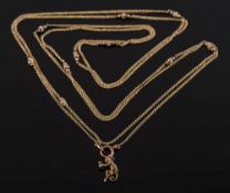 A gold and seed pearl long guard chain: with attached 'monkey' charm, 22gms gross weight.