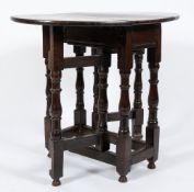 An 18th Century oak gateleg table:, of small size, with an oval hinged top,