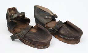 A pair of German diving clogs, the wooden sole with iron base and leather upper, 32cm long.
