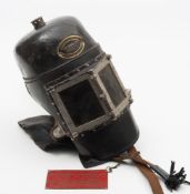 A black leather smoke helmet by Siebe Gorman & Co, London:, the rigid top with one -way outlet,