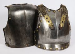 A polished steel and brass cuirass: with strap work to the breastplate and plain backplate