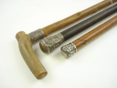 Two Indian white metal mounted walking canes and a silver mounted horn handled walking cane:.