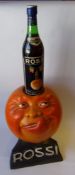 A plaster Rossi advertising figure: in the form of a large orange with a face that's licking its