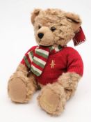 A brown plush Harrods Christmas bear 2010:, in a red jumper with scarf.