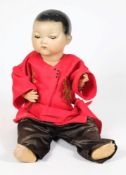 An Armand Marseille bisque head Oriental doll : with moulded hair, fixed brown eyes, closed mouth,