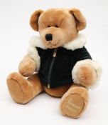 A brown plush Harrods Christmas bear 2001:, in a green jacket.