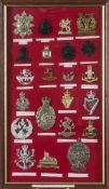 Twenty two Territorial British army cap badges:. mounted and framed.