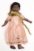 An early 20th century Continental bisque headed black doll:, applied wig with beaded headpiece,