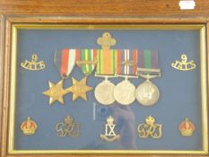 A framed WWII group of four with seven surrounding badges:, 1939-45 Star, Pacific Star, War Medal,